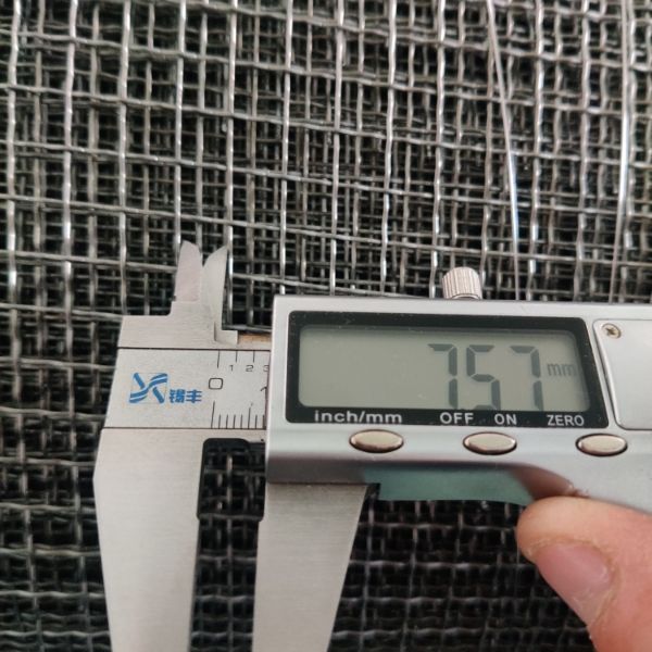 A caliper is used to check the opening size of molybdenum woven mesh.