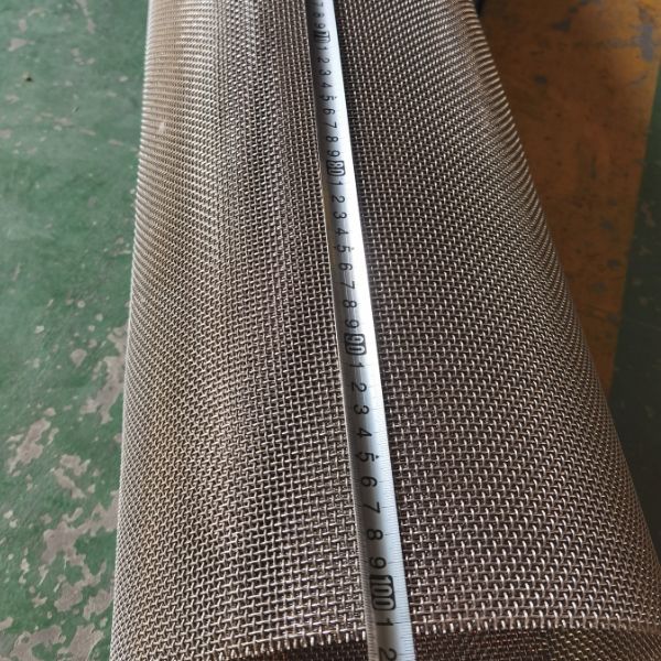 A tapeline is used to check the width of monel woven mesh.